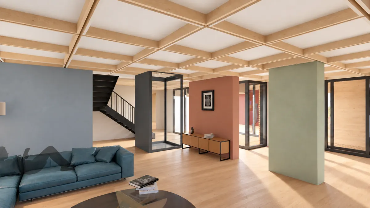 Ein Wohnraum unter der Rippendecke aus massivem Holz: links ein blaues Sofa vor blaugrauer Wand, dahinter eine schwarze Treppe und ein verglaster Aufzug, in der Mitte eine terrakottafarbene und rechts eine blassgrüne Wandscheibe, dazwischen Glastüren ins Freie.