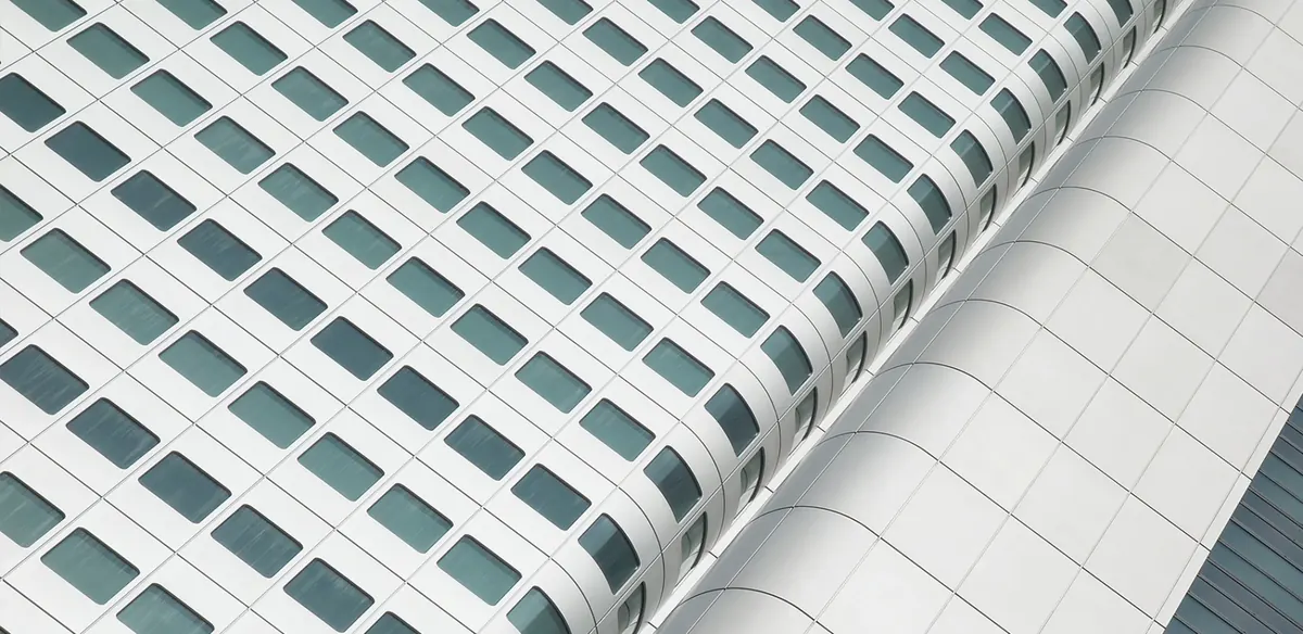 Fassade eines Hochhauses mit regelmäßigen Fensterbändern, steil von unten gesehen